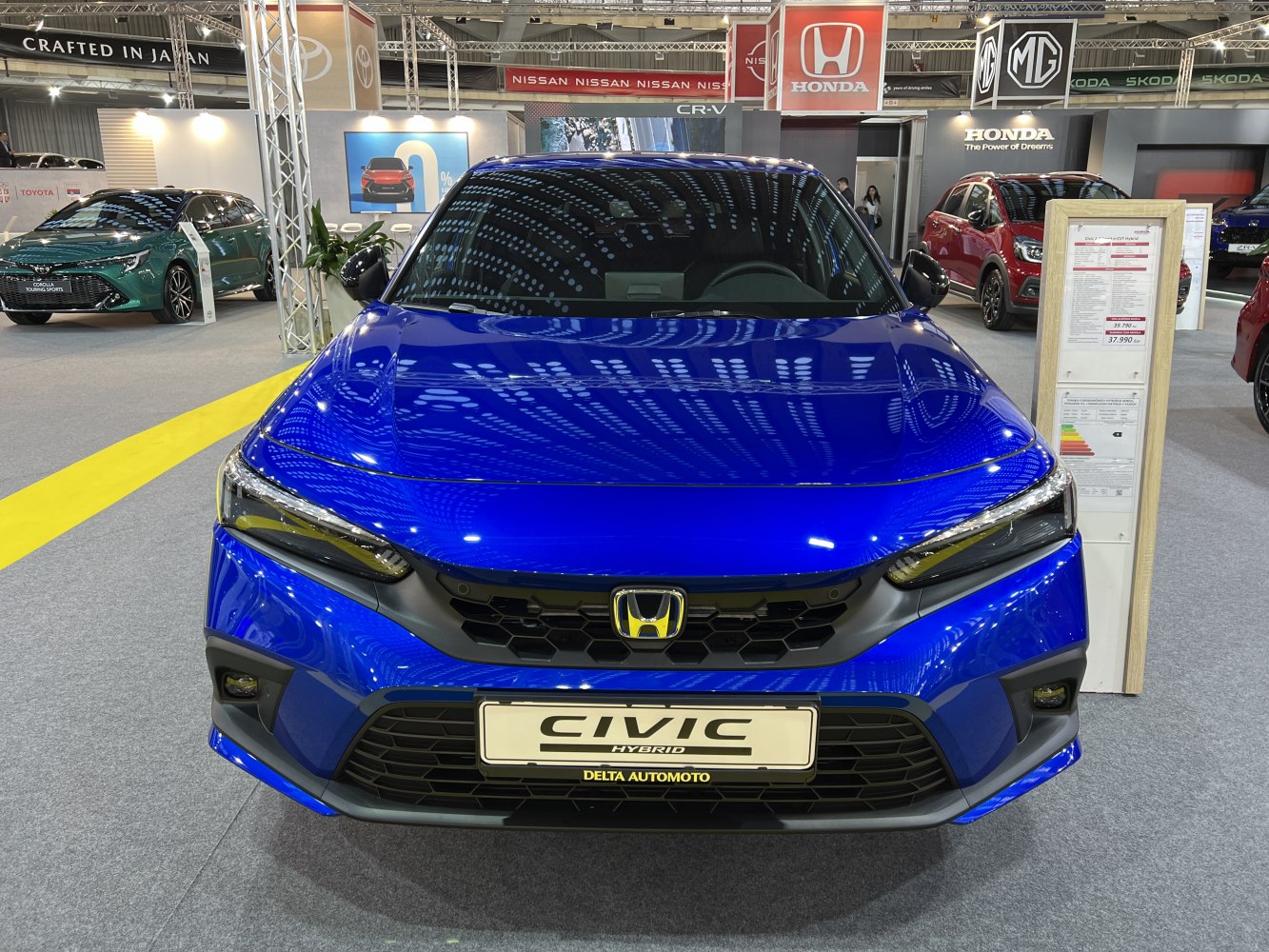 Front view of a blue vehicle with hybrid badge and sleek headlights