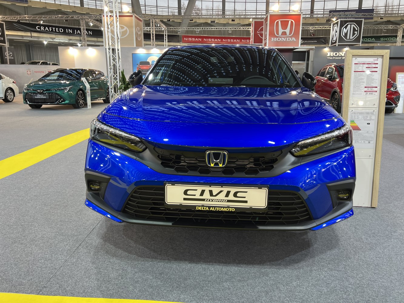 Front view of sleek blue hybrid with black grille and headlights