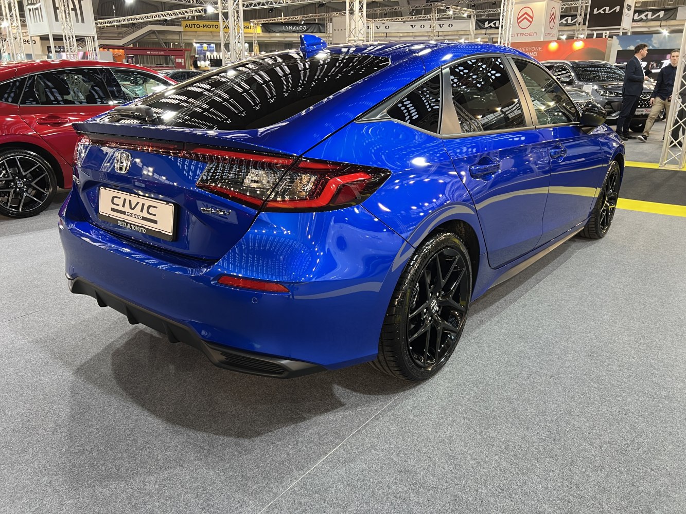 Rear view of sleek blue sedan with black alloy wheels and modern taillights
