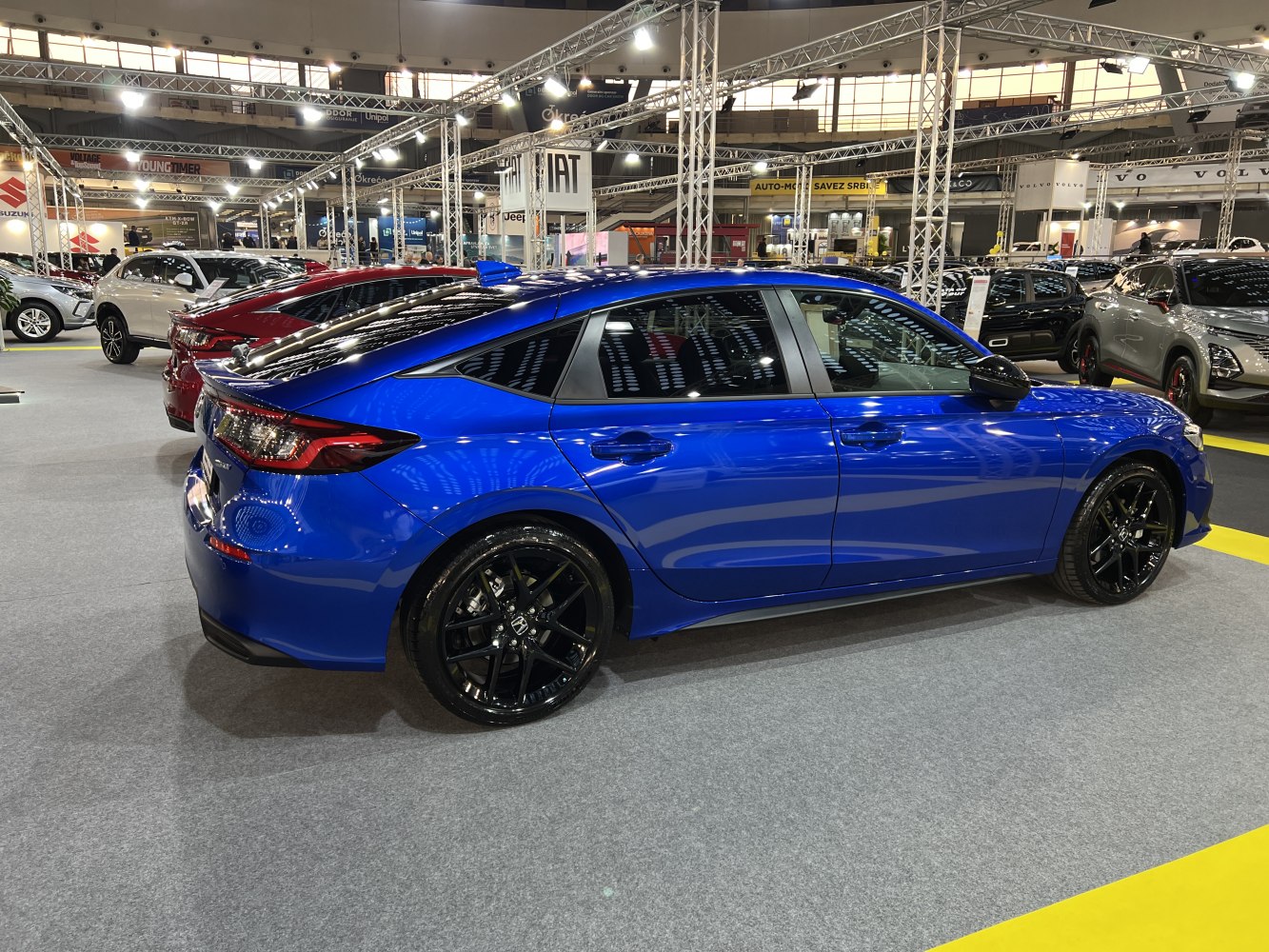 Blue sedan with black alloy wheels and aerodynamic sporty profile