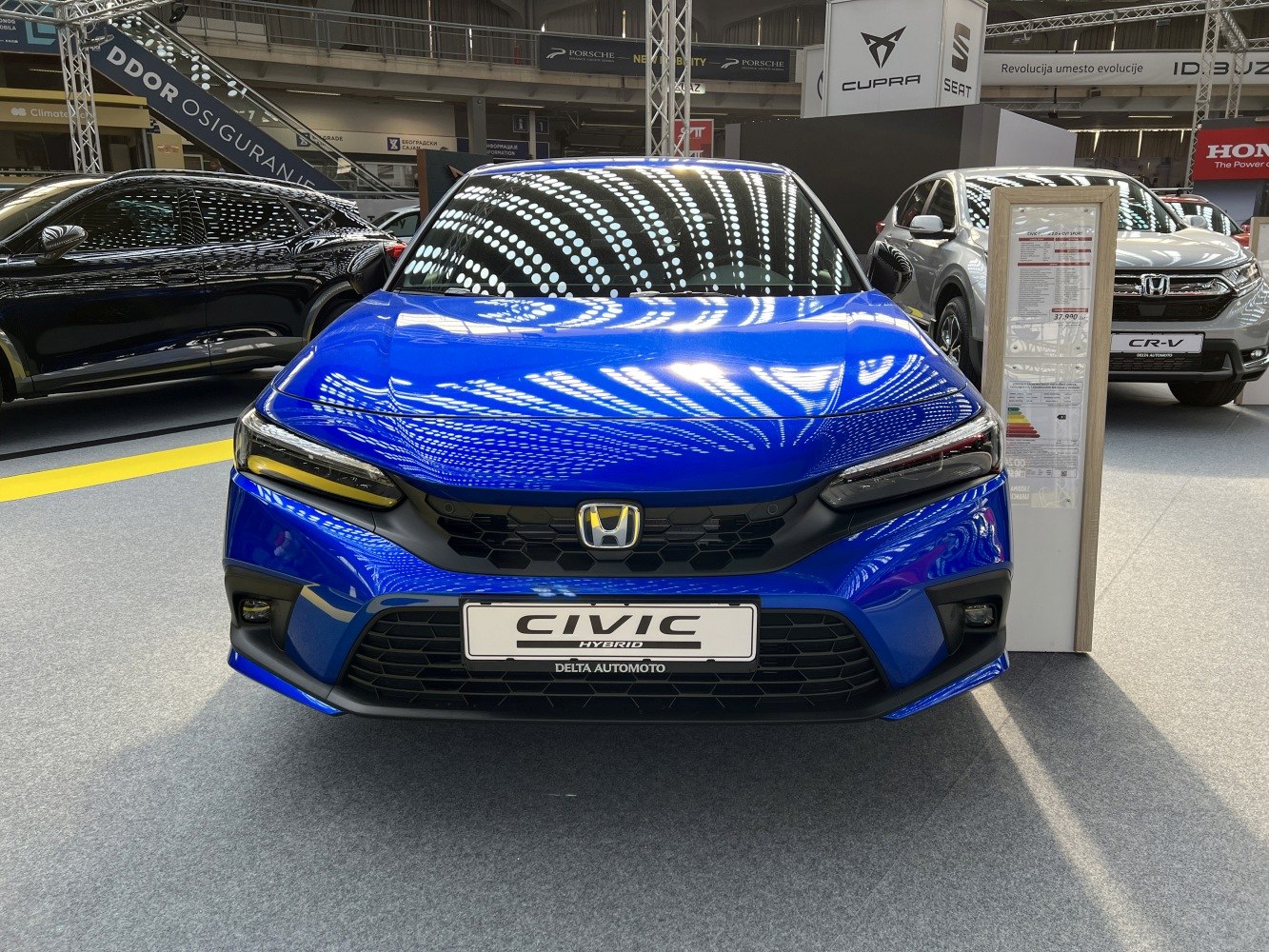Front view of blue modern sedan with hybrid badge and LED headlights