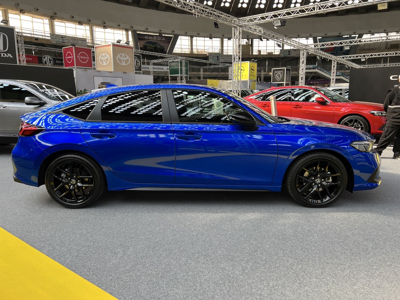 Sporty blue hatchback with black alloy wheels and sleek aerodynamic profile