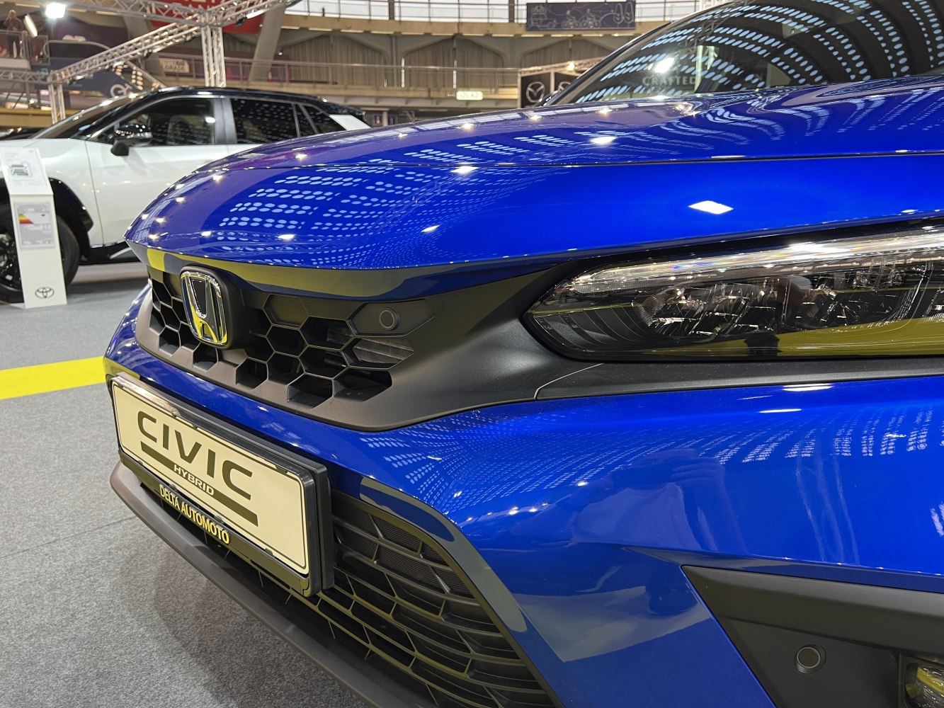 Close-up of honeycomb grille and sleek headlight assembly.