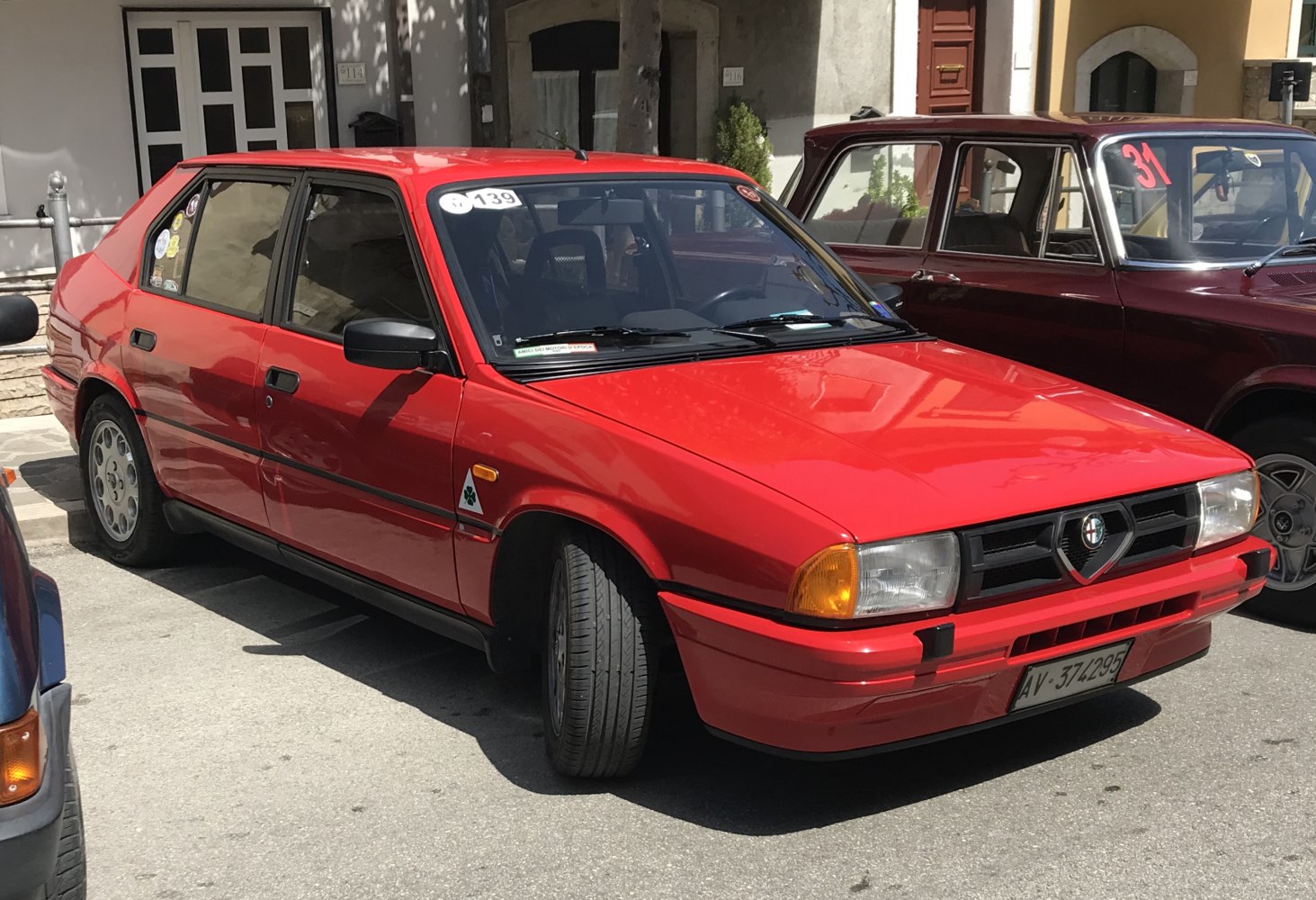 Red five-door hatchback with distinctive front grille and sporty side profile