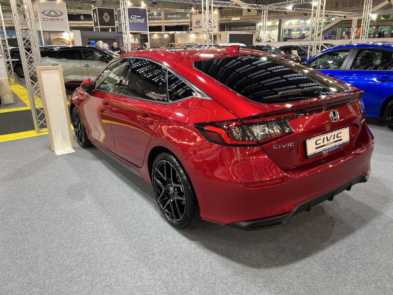 Red sedan with black alloy wheels and rear spoiler