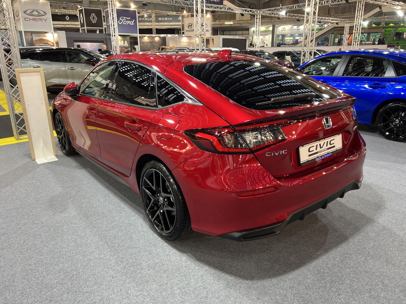 Rear view of hybrid hatchback with black alloy wheels and tinted windows