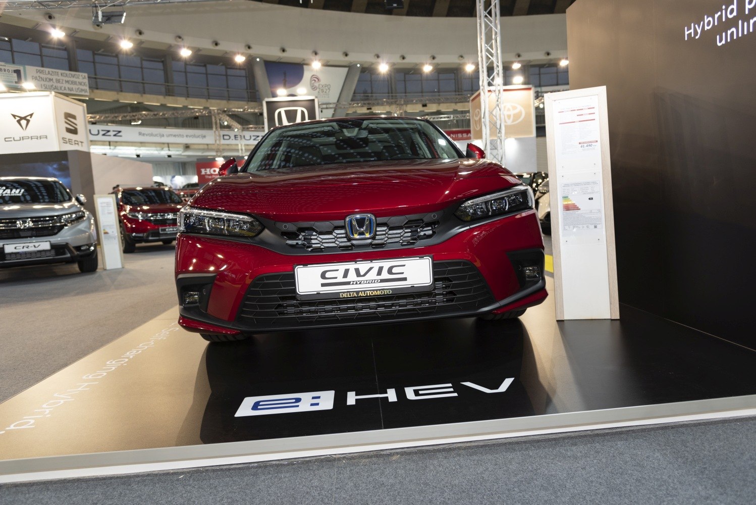 Front view of a red modern sedan with hybrid e:HEV badging and LED headlights