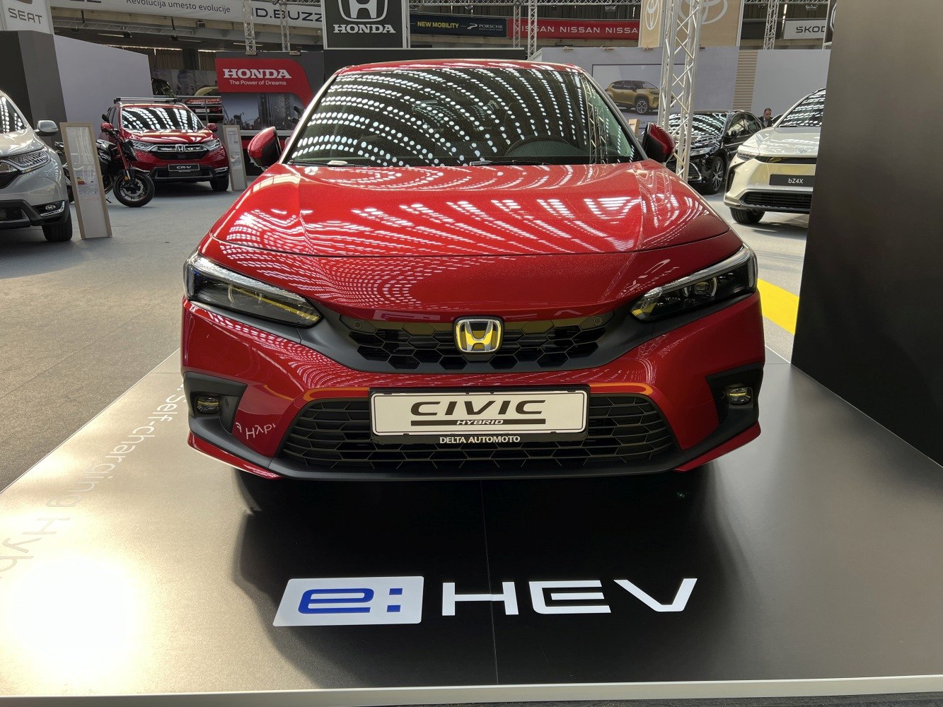 Front view of a 2022 hybrid vehicle with sleek LED headlights and a distinctive grille.