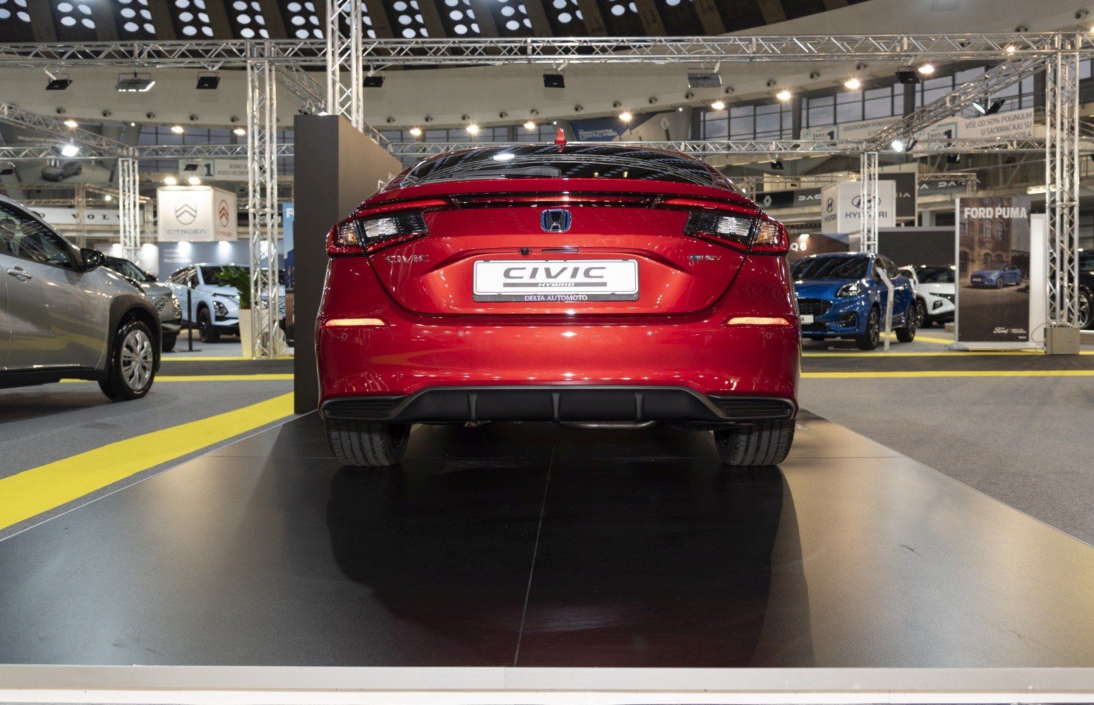 Rear view with hybrid badge and modern tail lights of a hatchback.