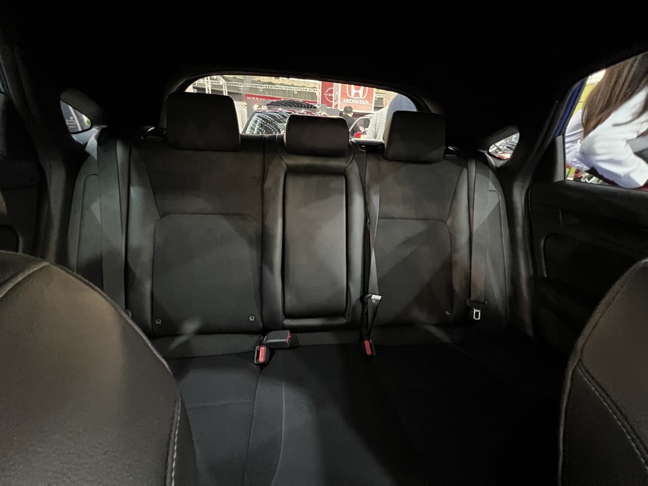 Black leather rear passenger seating with headrests and seat belts