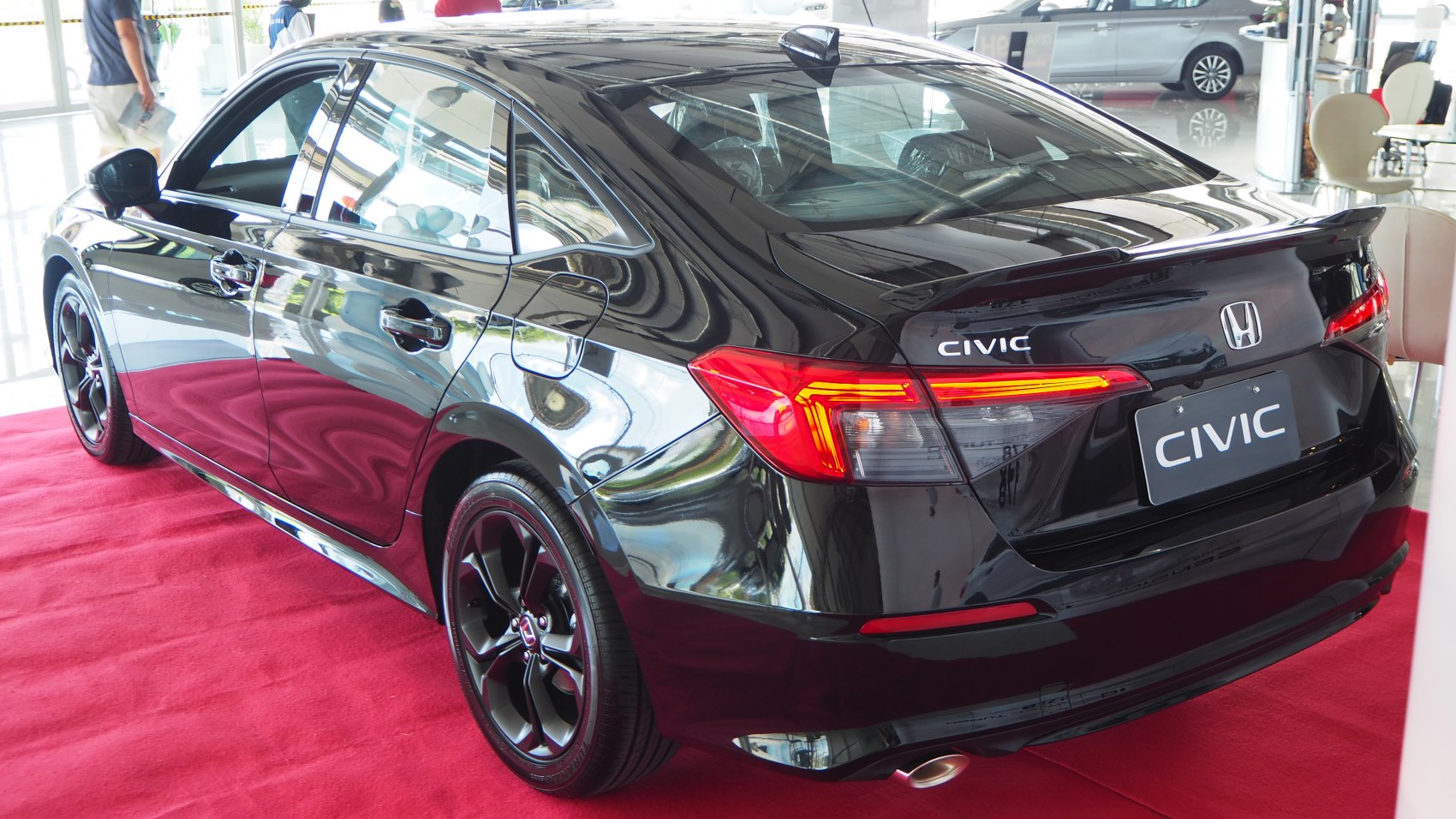 Rear view of a black sedan with LED tail lights and rear spoiler