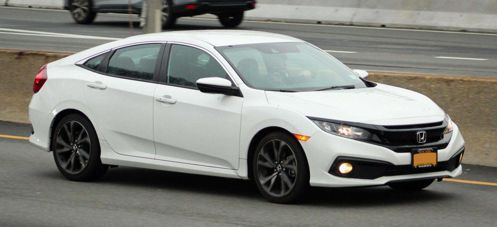 White sedan with sporty black alloy wheels and LED headlights