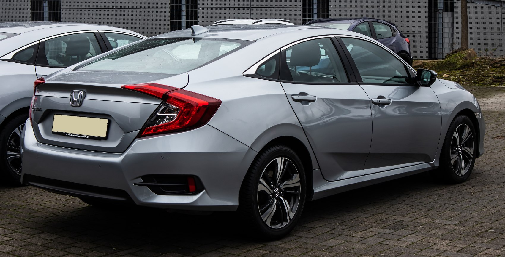 Silver sedan rear view with distinctive angular taillights and alloy wheels
