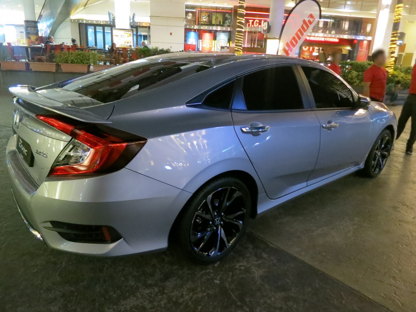 Rear side view of sleek sedan with spoiler and tinted windows