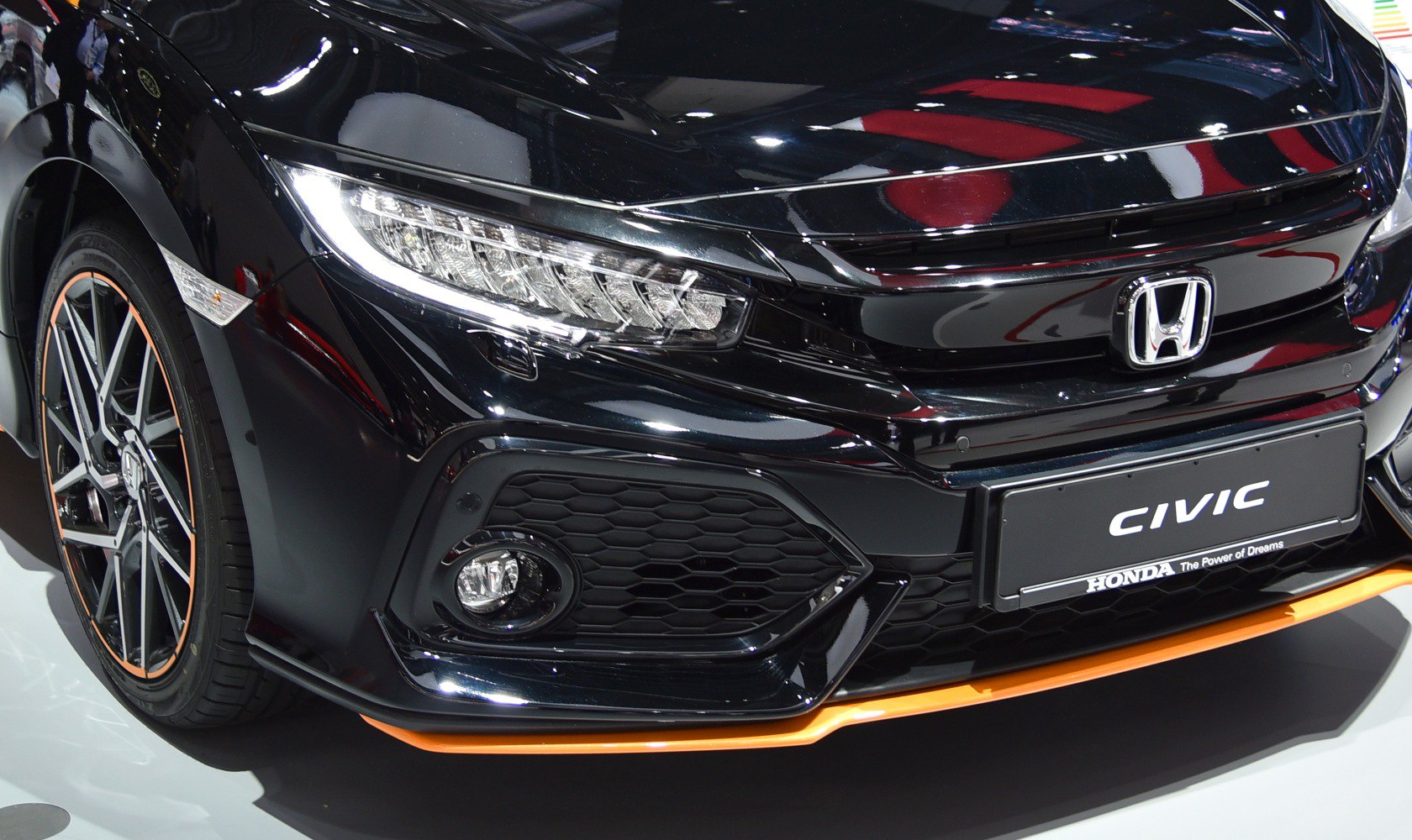 Front grille, headlight, fog light, and wheel rim close-up.