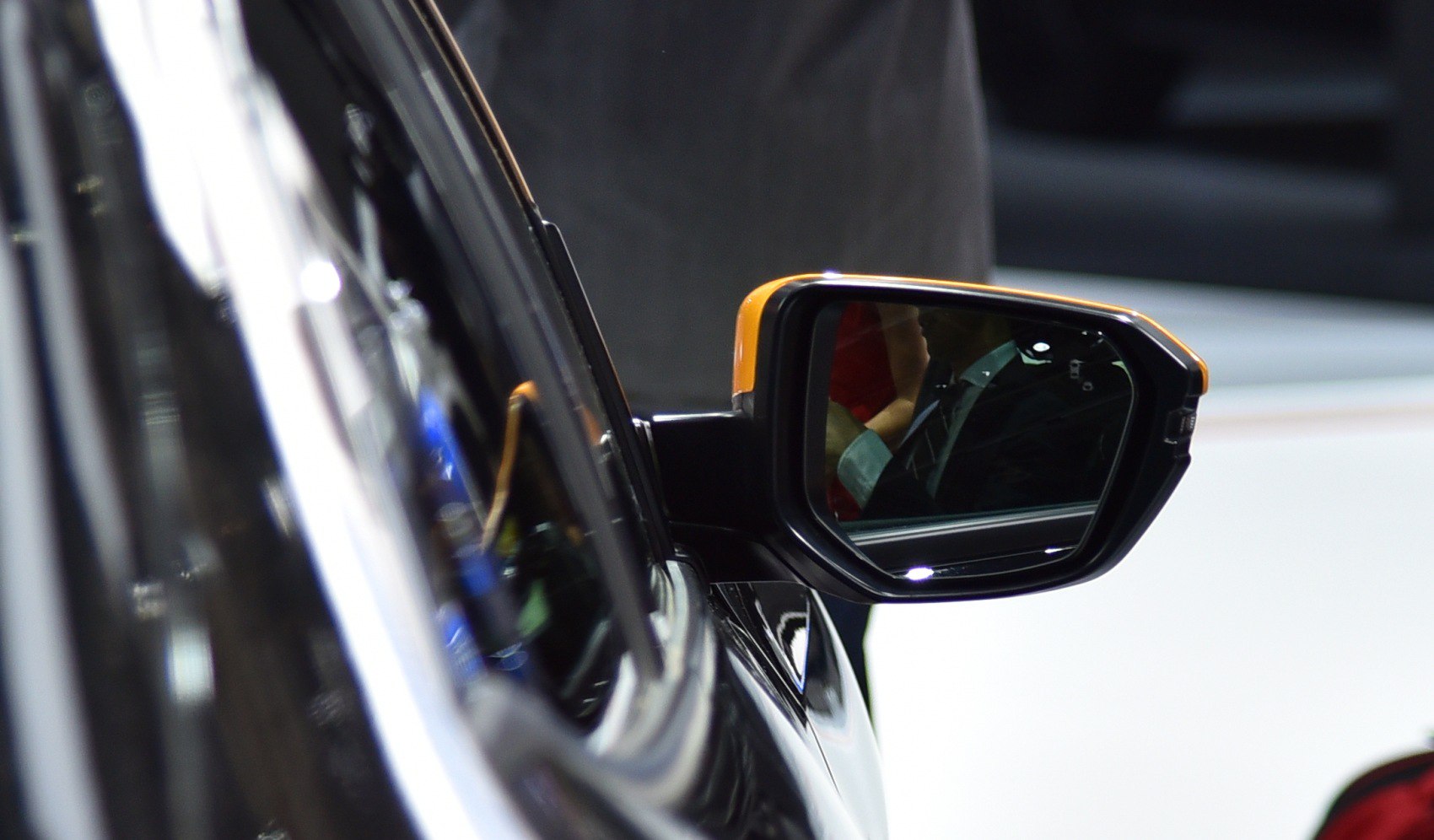 Close-up of sleek side mirror with yellow accent