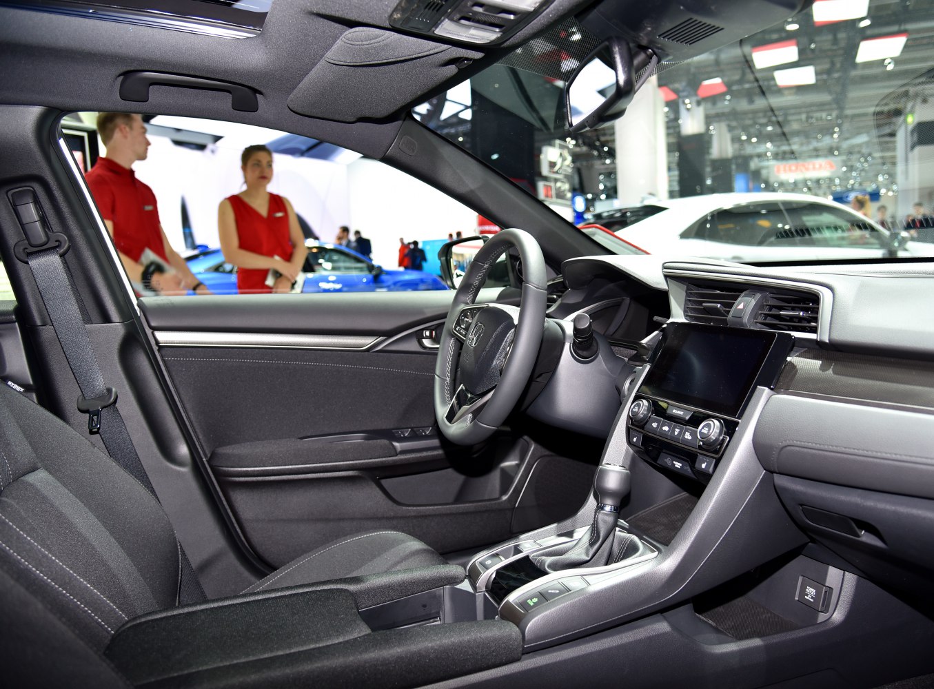 Modern hatchback interior with touchscreen, steering wheel, and gear shift