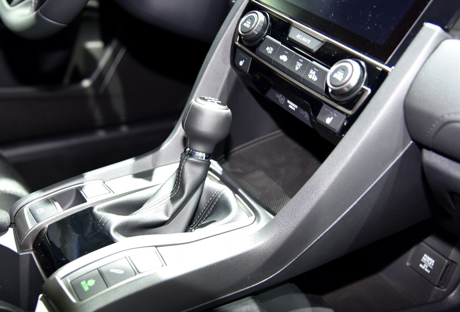 Manual gear shift and climate control panel with buttons and knobs