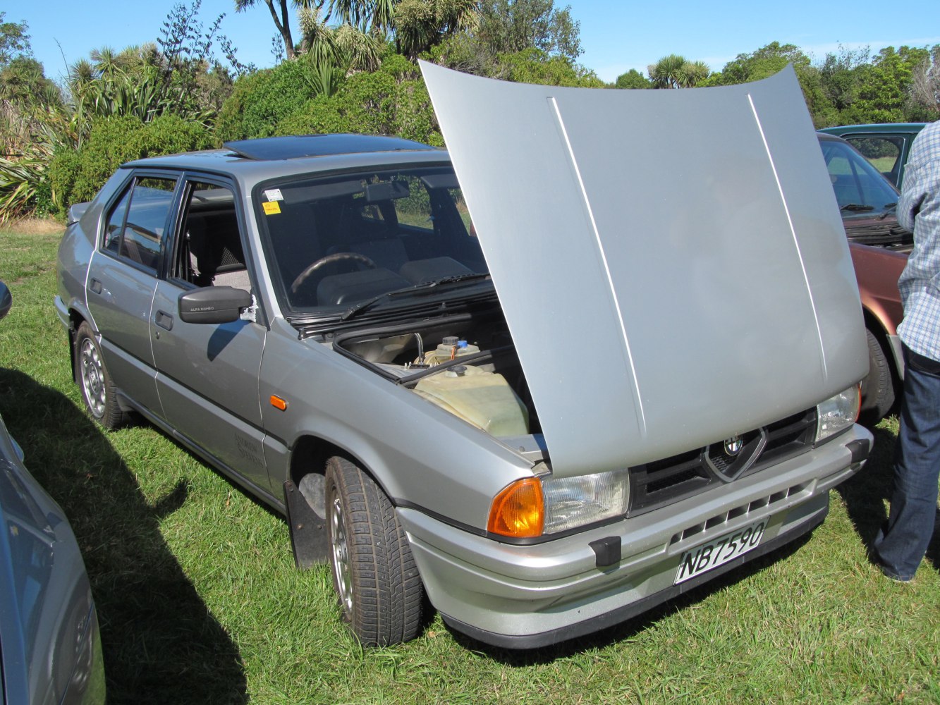 Silver hatchback with open hood showing front end and engine compartment