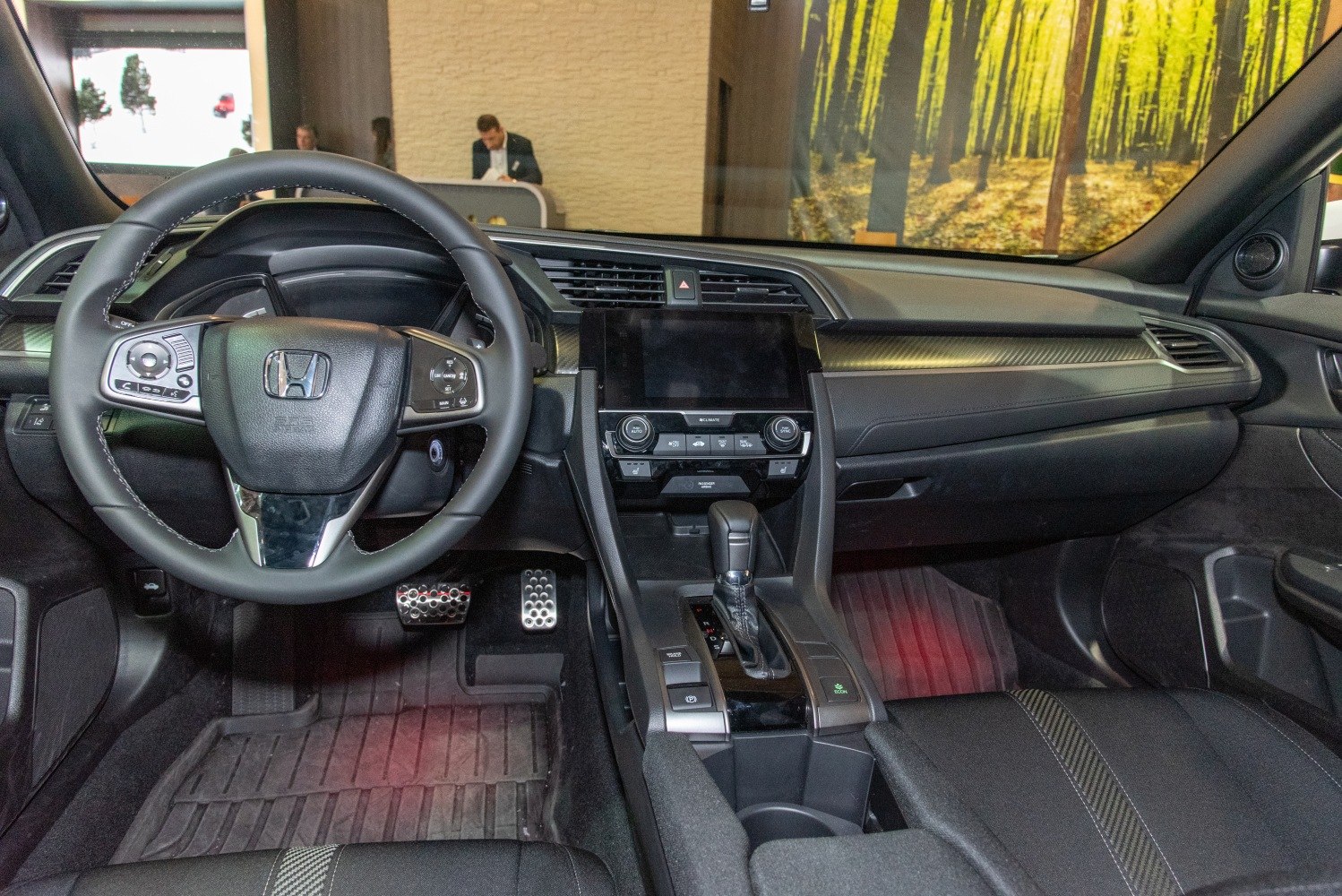 Dashboard and multifunction steering wheel inside vehicle with center console.