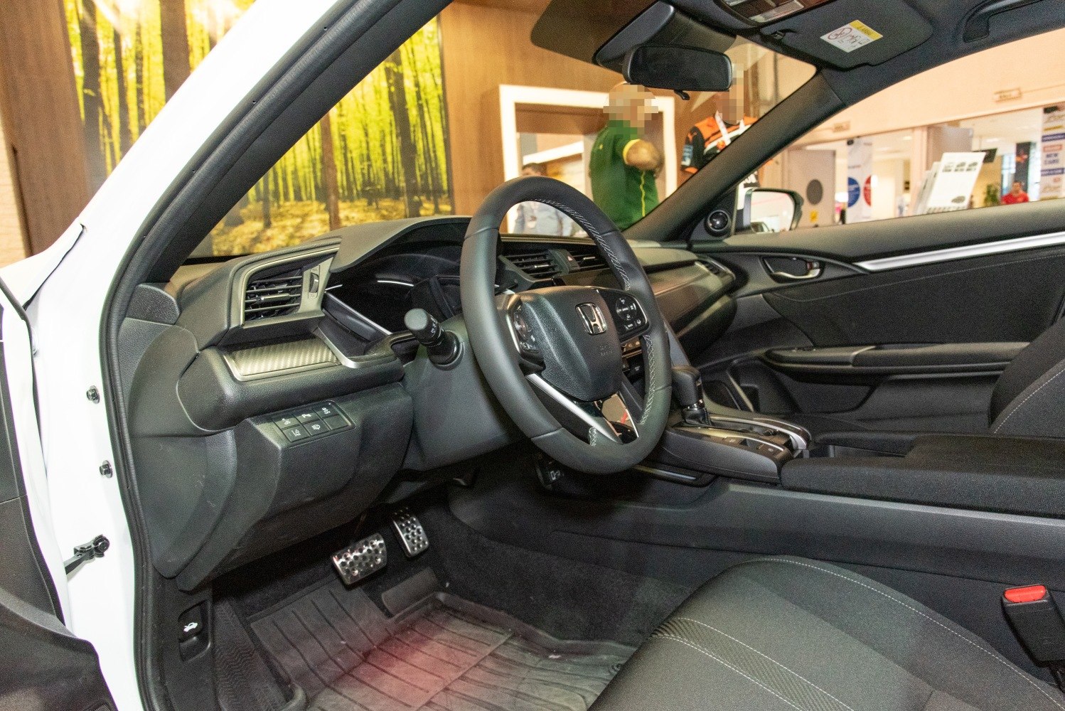 Dashboard and steering wheel with pedals inside a vehicle
