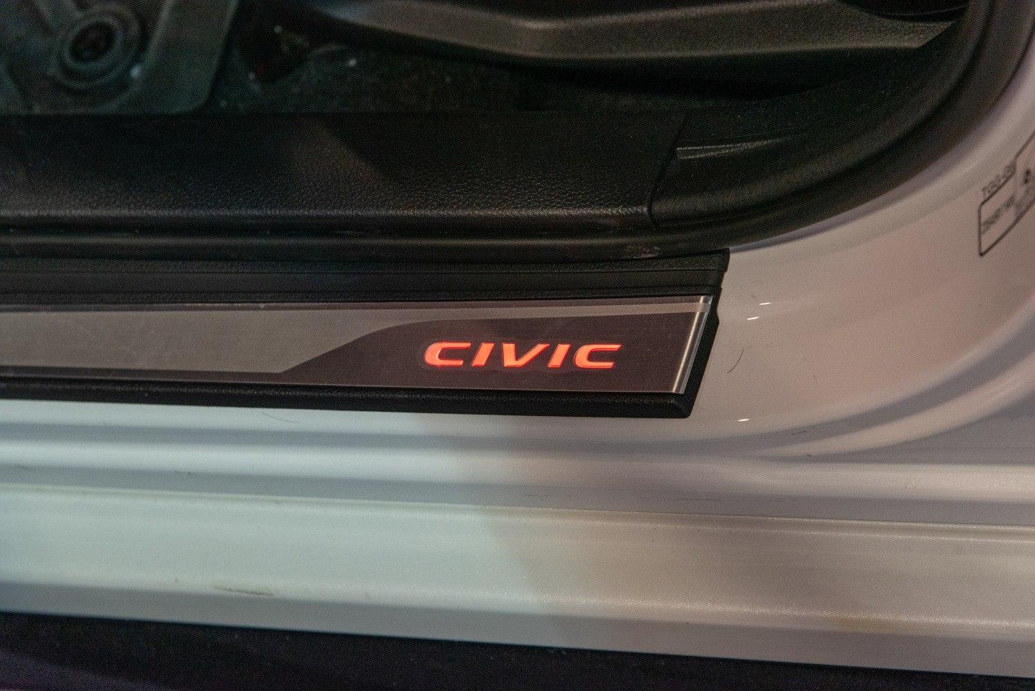 Illuminated door sill plate with brand lettering
