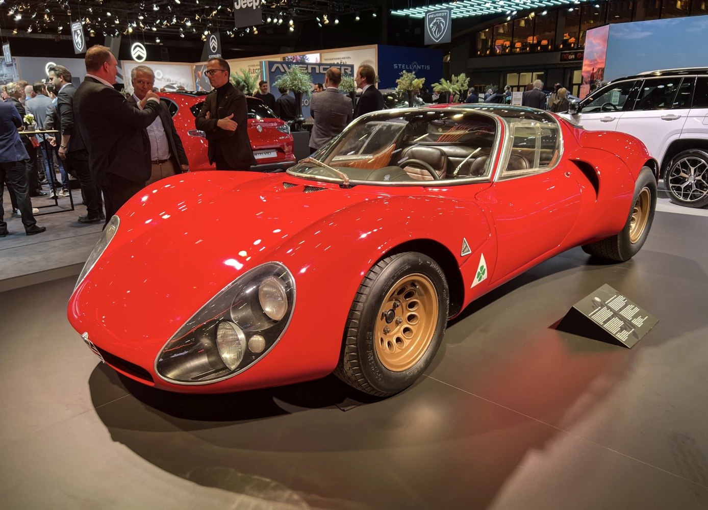 Red classic sports car with gold wheels and aerodynamic design