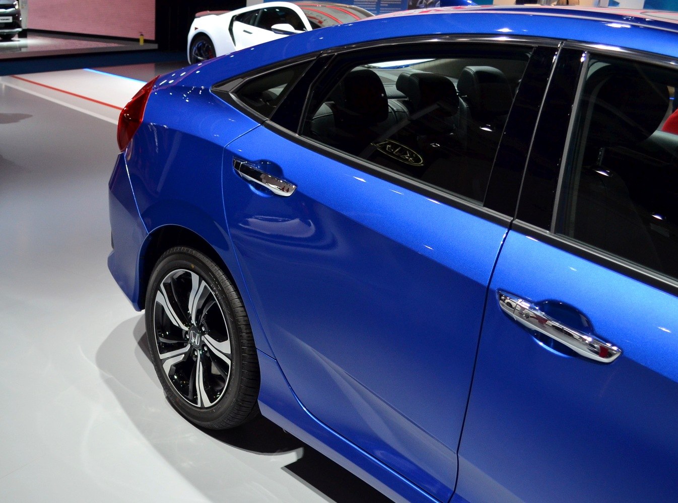 Blue sedan rear side with alloy wheel and chrome door handle