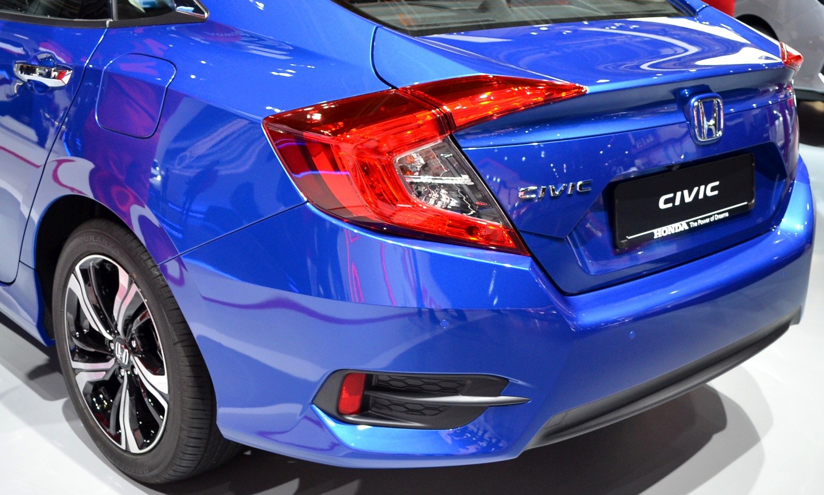 Close-up of rear tail light and alloy wheel of a blue modern sedan