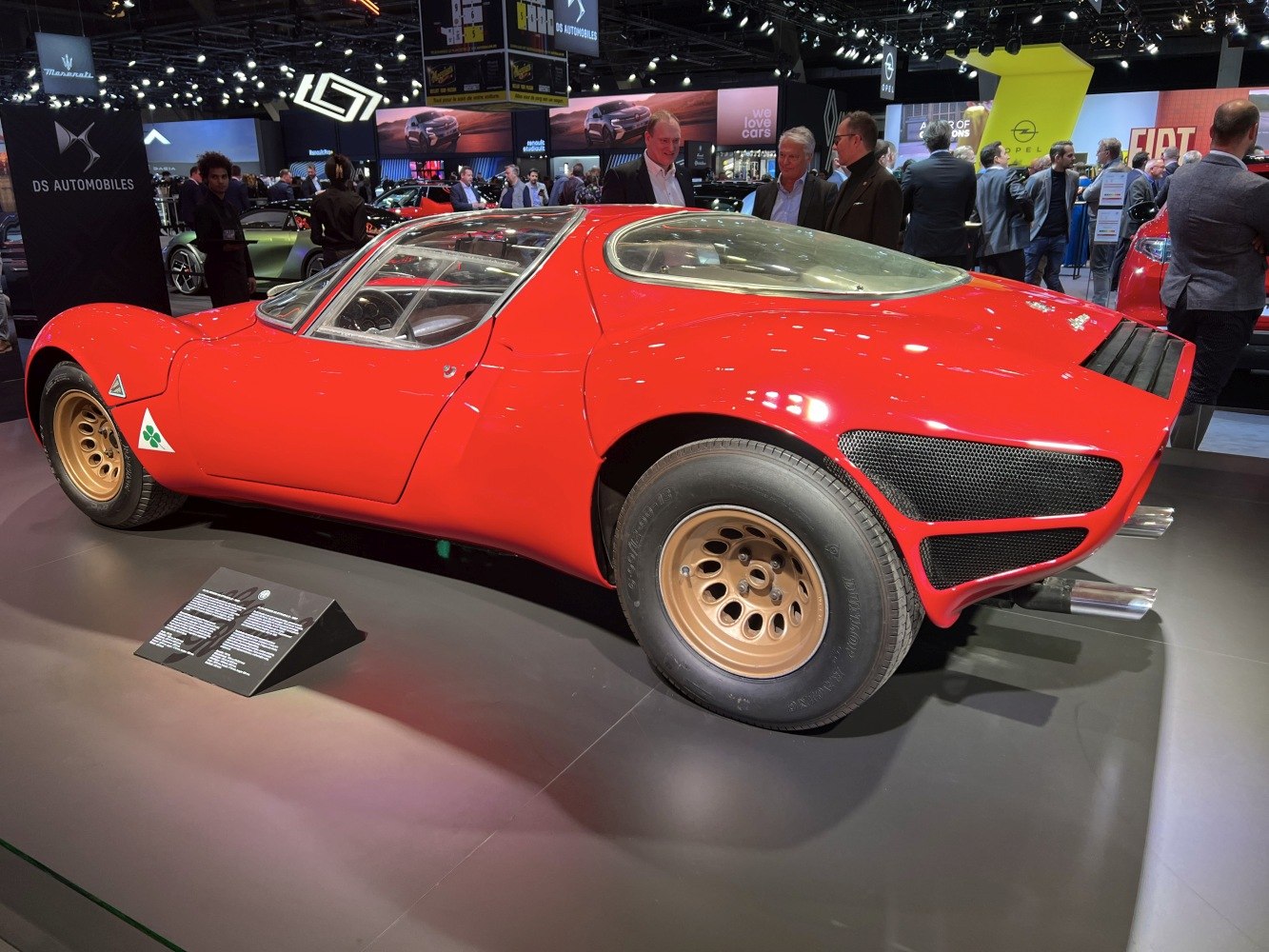 Red sports coupe with rear vented panels and gold wheels