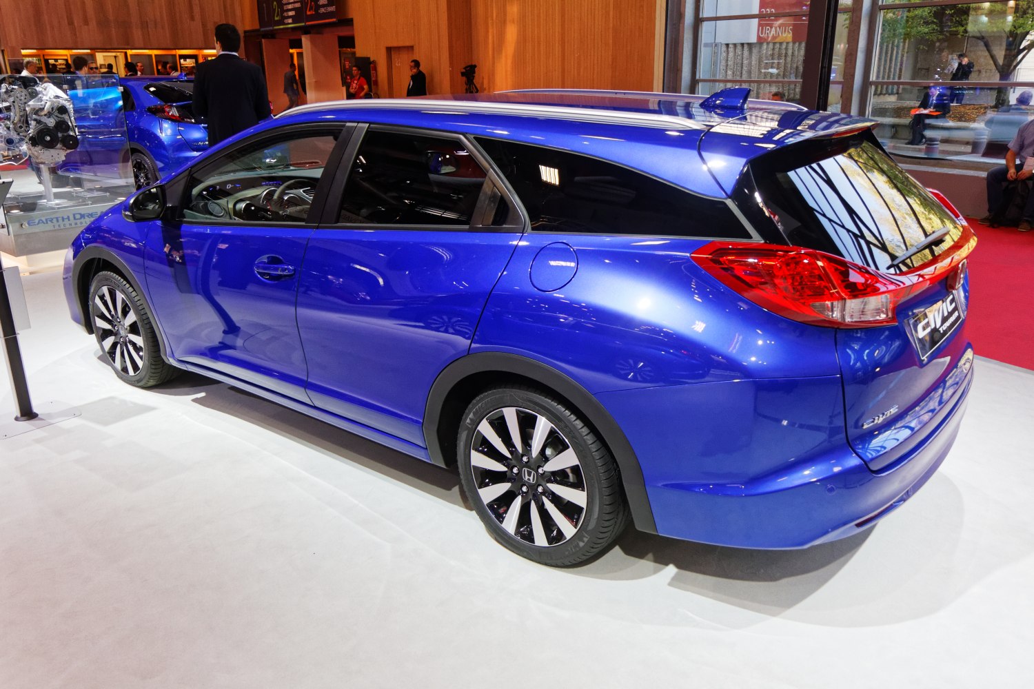 Rear and side profile of blue hatchback with alloy wheels and roof spoiler