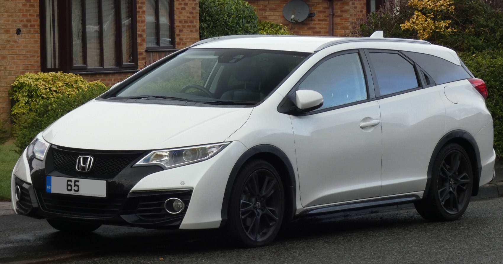 White hatchback with black trim and sporty design features