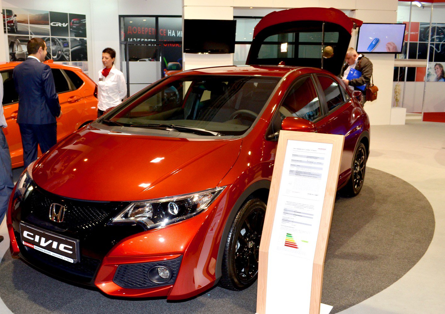 Red hatchback with sleek headlights and open trunk