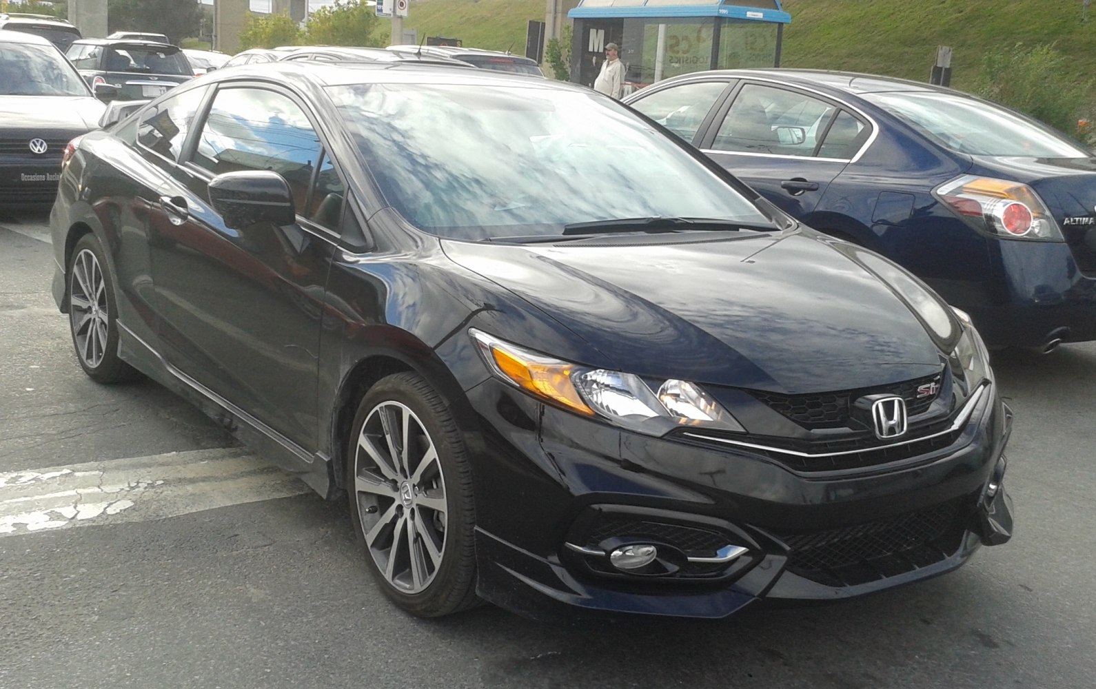 Black coupe with sleek headlights and alloy wheels