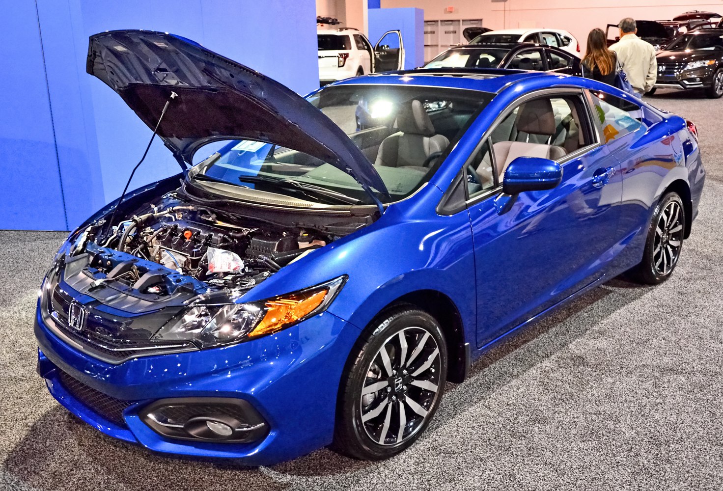 Blue coupe with open hood showcasing the engine and detailed front design