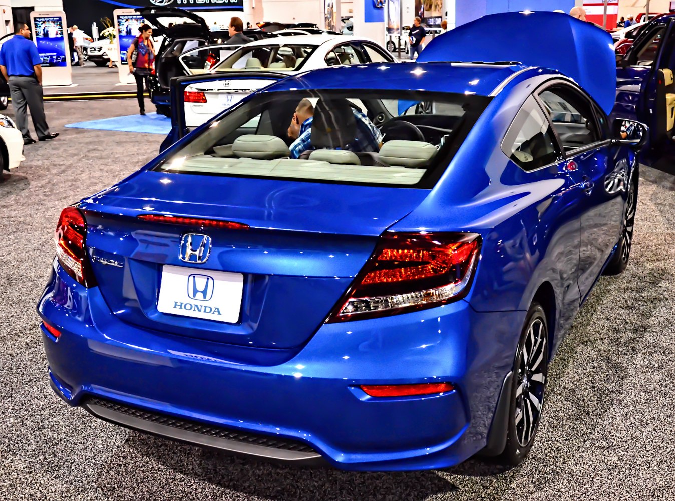 Rear view of a blue 2-door coupe with modern tail lights and sleek design