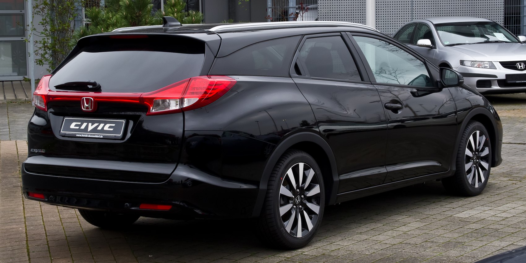 Rear and side view of black wagon with modern tail lights and sporty wheels