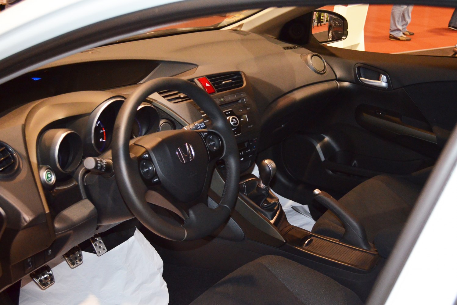 Manual gear shift and sporty steering wheel in car interior