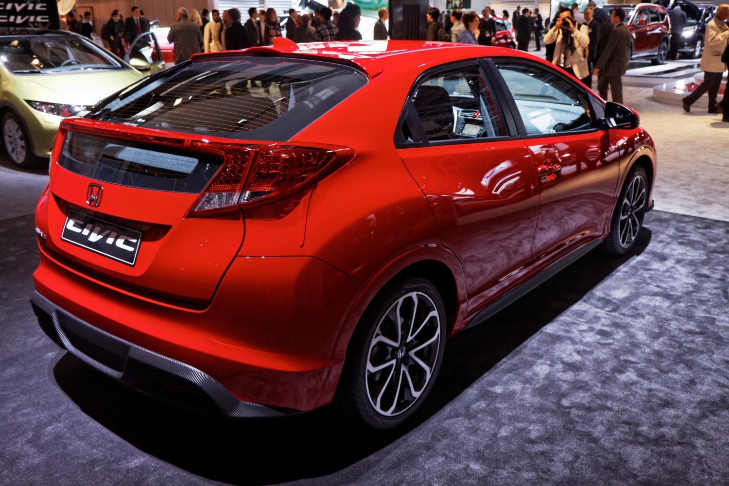 Red hatchback rear and side view with aerodynamic design and alloy wheels