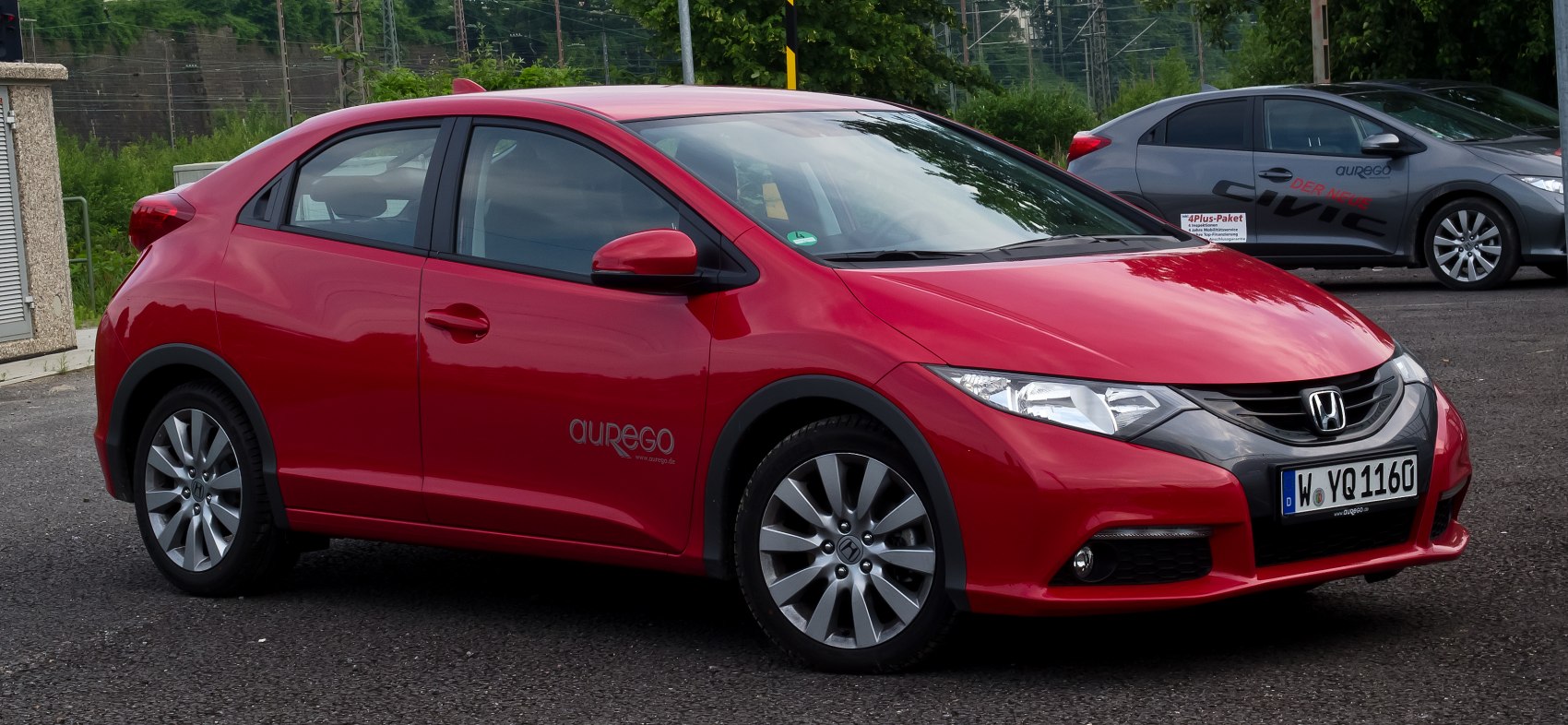Red sleek hatchback with sharp headlights and alloy wheels
