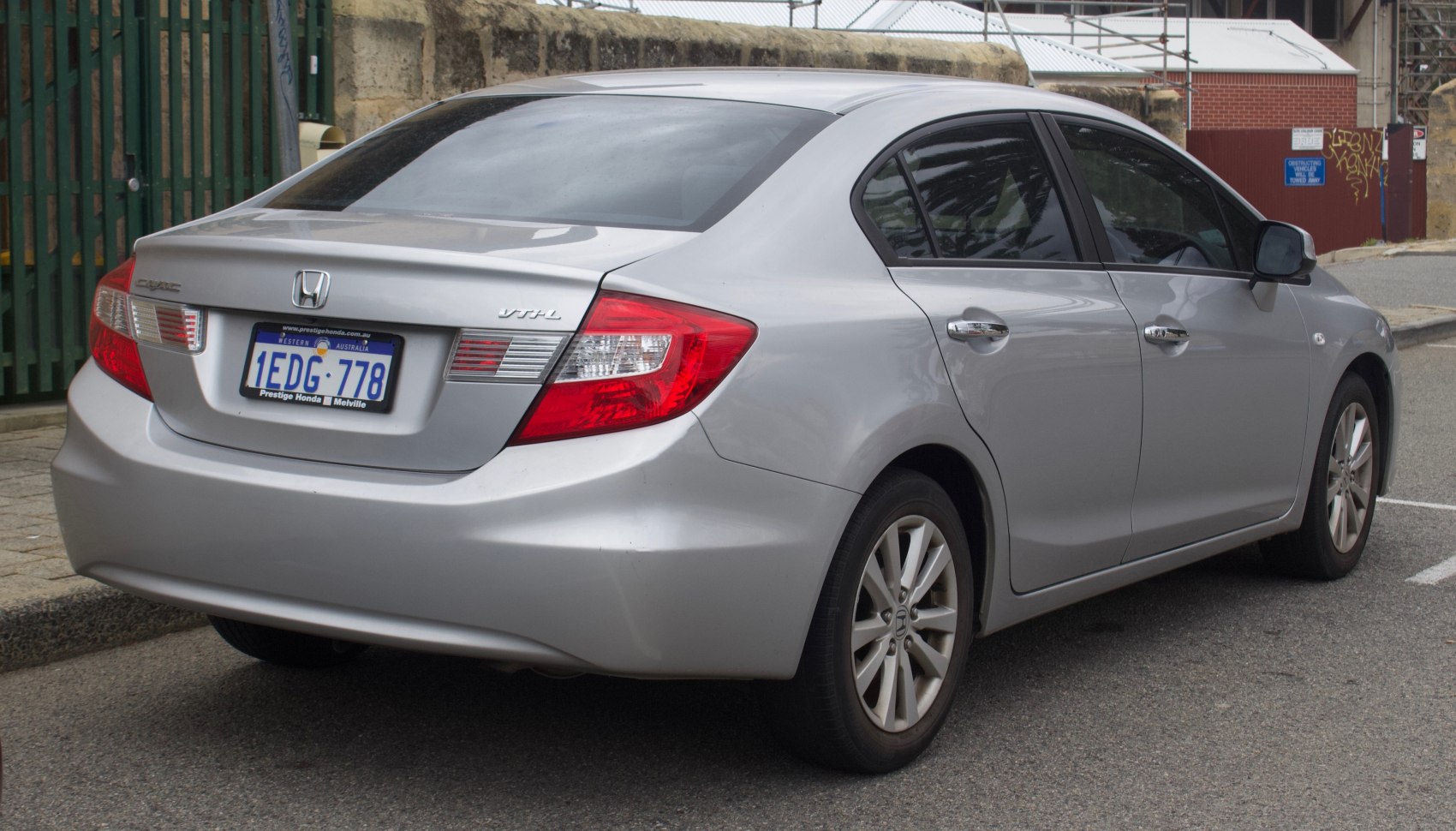 Rear and side view of a silver sedan with distinctive taillights and alloy wheels