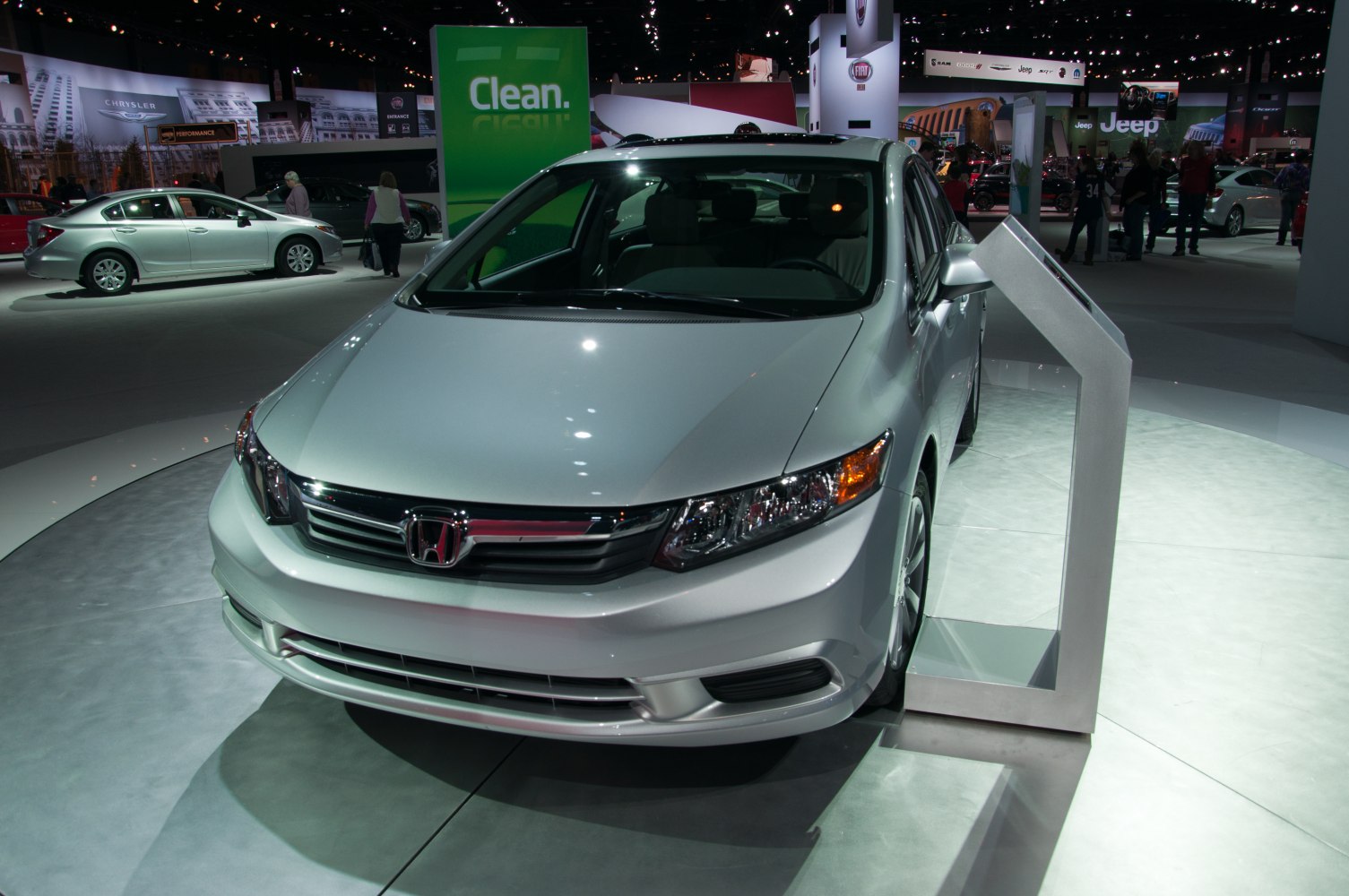 Front view of silver sedan with modern headlights and chrome grille