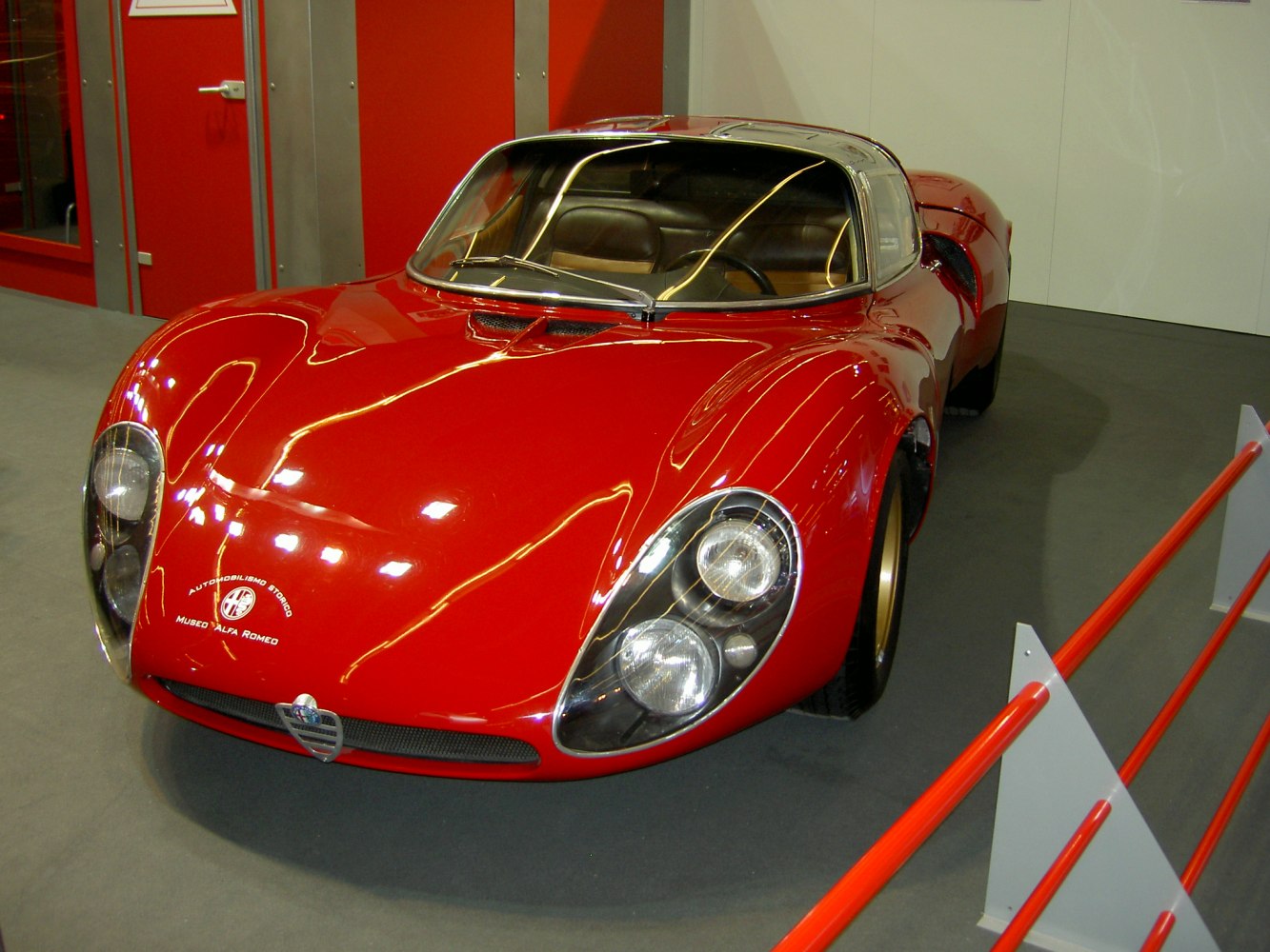 Red classic sports coupe with curved headlights and aerodynamic shape