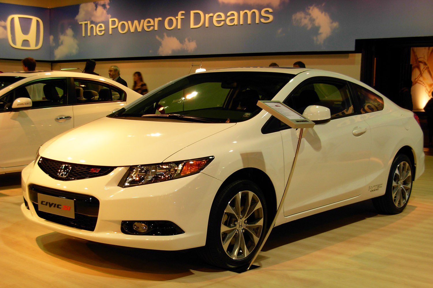 Front-side view of a coupe with sleek headlights and alloy wheels