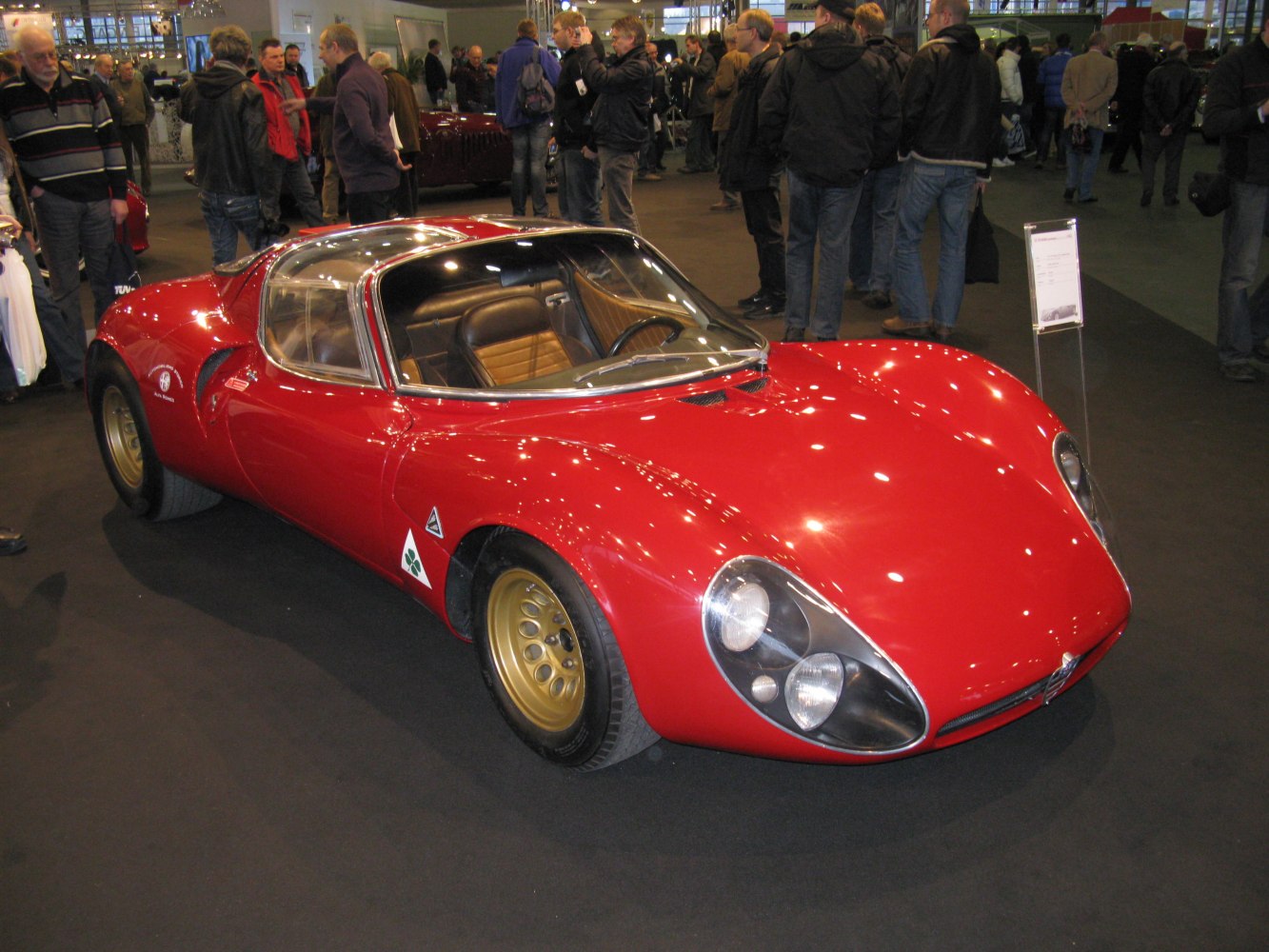 Vintage red sports coupe with dome headlights and gold rims