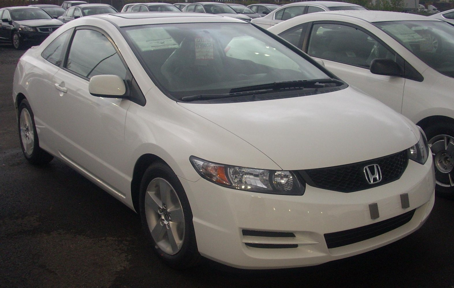 White coupe with distinct front headlights and alloy wheels