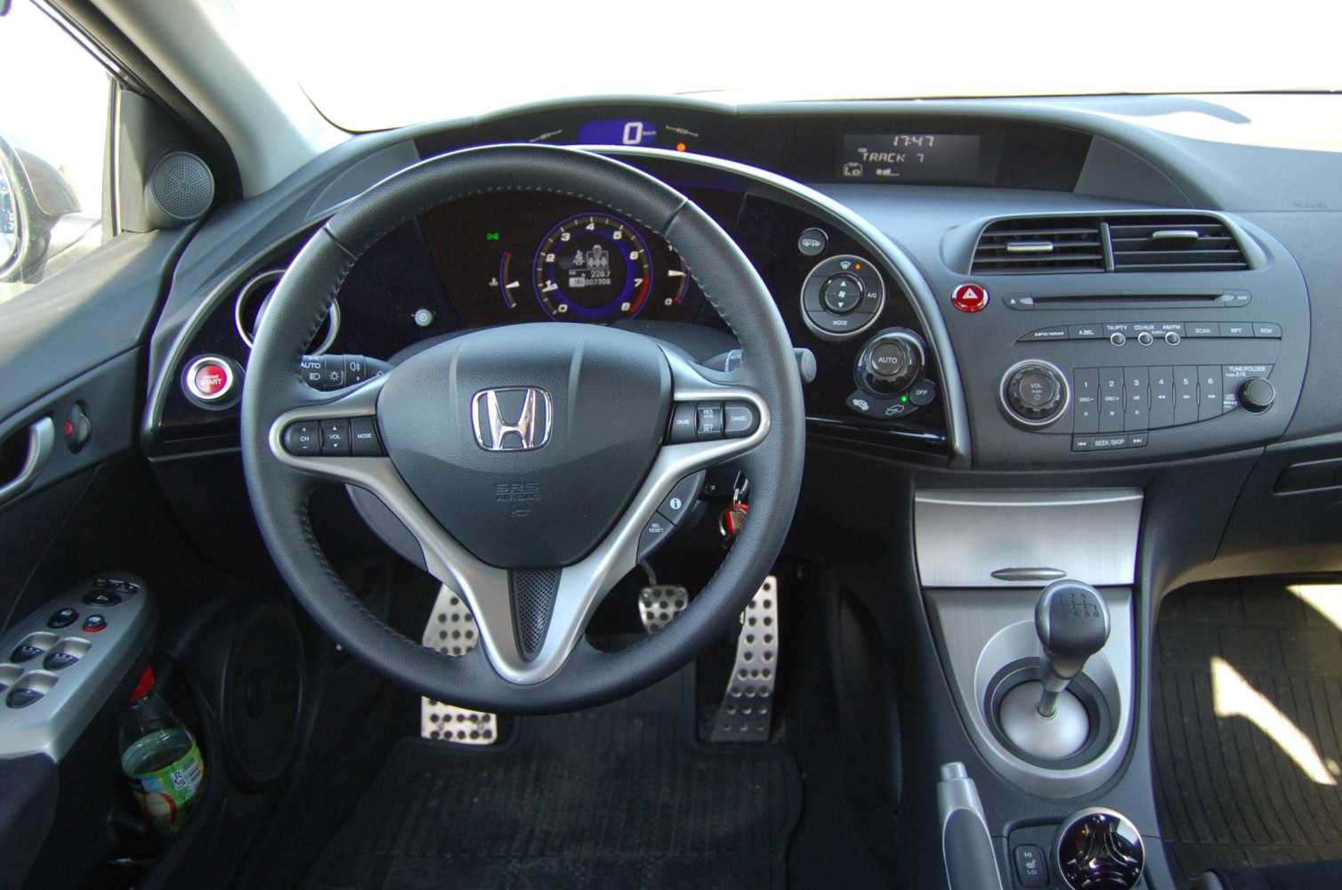 Steering wheel, dashboard, and manual gear shifter of compact hatchback