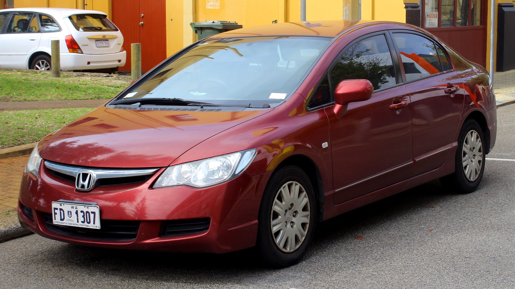 Red sedan with clear headlights and silver alloy wheels