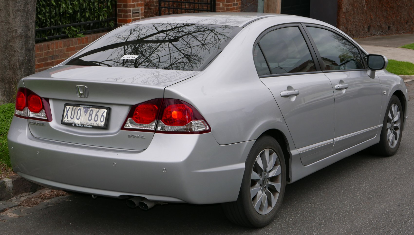 Silver sedan rear and side view with taillights and alloy wheels