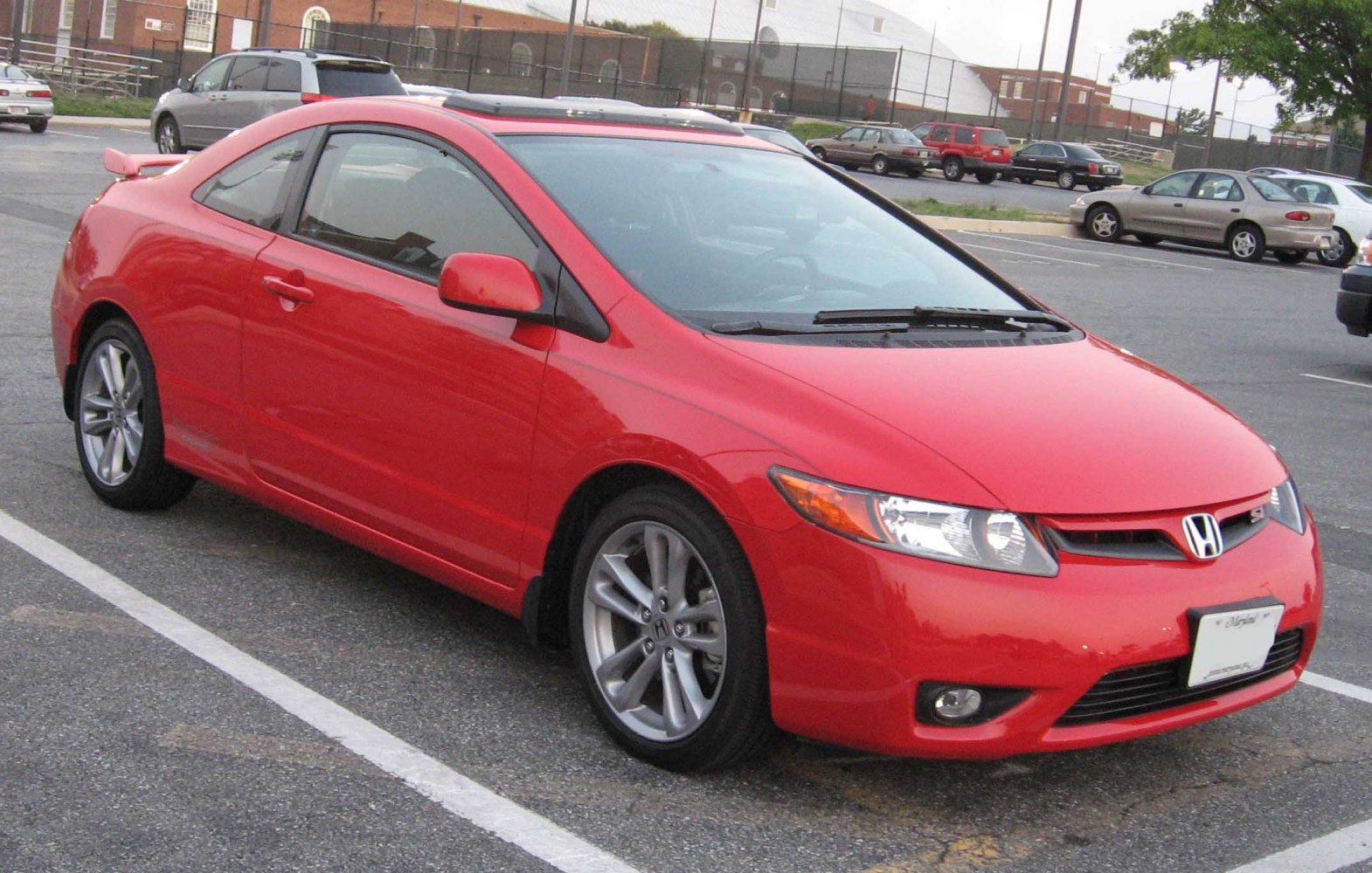 Red two-door coupe with alloy wheels, rear spoiler, and sunroof